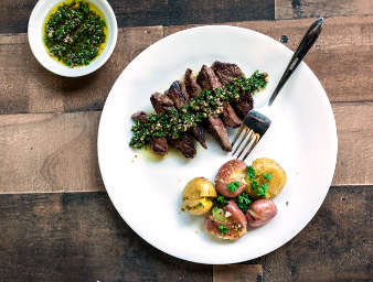 Seared steak strips with chimichurri sauce and potatoes